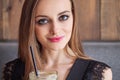 Closeup portrait of young adorable woman with gorgeous eyes trendy makeup drinking big glass cup of coffee with straw Royalty Free Stock Photo