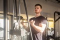 Closeup portrait of young adult sport athlete man training at gym alone, standing and lifting weights in the gym, doing exercises