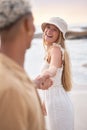 Closeup portrait of an young affectionate mixed race couple standing on the beach holding hands and smiling during Royalty Free Stock Photo