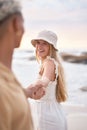 Closeup portrait of an young affectionate mixed race couple standing on the beach holding hands and smiling during Royalty Free Stock Photo