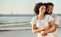 Closeup portrait of an young affectionate mixed race couple standing on the beach and smiling during sunset outdoors Royalty Free Stock Photo