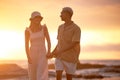 Closeup portrait of an young affectionate mixed race couple standing on the beach and smiling during sunset outdoors Royalty Free Stock Photo