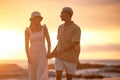 Closeup portrait of an young affectionate mixed race couple standing on the beach and smiling during sunset outdoors Royalty Free Stock Photo