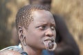 A closeup shot of a young African male with traditional body modifications from the Mursi Tribe