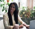 Closeup portrait of young african woman relaxing in cafe with laptop and making phone call, lifestyle and people concept Royalty Free Stock Photo