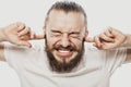 Closeup portrait young, angry, unhappy, stressed man covering his ears isolated on white background. Royalty Free Stock Photo