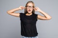 Closeup portrait, young angry, unhappy, stressed woman covering closed ears, looking away annoyed by loud noise, giving her headac Royalty Free Stock Photo