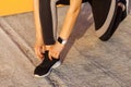 Closeup portrait of young attractive sporty woman wearing black sporwear in morning on street standing on knee and preparing for Royalty Free Stock Photo