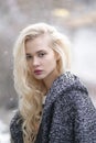 Closeup portrait of young beautiful blond woman face posing outside in winter time