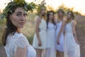 Closeup portrait of a young beautiful girl in a white dress, a floral wreath on her head. Against the background of a young bride Royalty Free Stock Photo