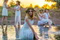 Closeup portrait of a young beautiful girl in a white dress, a floral wreath on her head. Against the background of a young bride Royalty Free Stock Photo