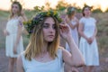 Closeup portrait of a young beautiful girl in a white dress, a floral wreath on her head. Against the background of a young bride Royalty Free Stock Photo