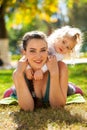 Closeup portrait of a young beautiful mother with little curly daughter in autumn park Royalty Free Stock Photo