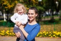 Closeup portrait of a young beautiful mother with little curly daughter in autumn park Royalty Free Stock Photo