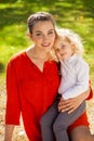 Closeup portrait of a young beautiful mother with little curly daughter in autumn park Royalty Free Stock Photo