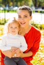 Closeup portrait of a young beautiful mother with little curly daughter in autumn park Royalty Free Stock Photo