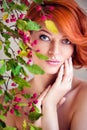 Closeup portrait of young beautiful redhaired woman with the sprig of spindle tree Royalty Free Stock Photo