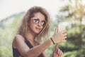 Closeup portrait of young beautiful woman in sunglasses with long blonde curly hair doing selfie photos Royalty Free Stock Photo