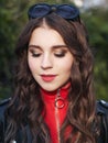 Closeup portrait of young brown-haired curly woman with trendy creative red makeup posing outdoors in bright sunlight. Pretty girl Royalty Free Stock Photo