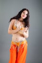 Closeup portrait of young brunette lady poses in orange belly dancer costume