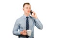 Closeup portrait of young businessman dressed in blue shirt and tie, talking on the mobile phone, isolated on white background Royalty Free Stock Photo