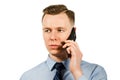 Closeup portrait of young businessman dressed in blue shirt and tie, talking on the mobile phone, isolated on white background Royalty Free Stock Photo