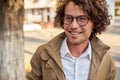 Closeup portrait of young businessman with glasses smiling and posing outdoors. College male student in autumn street. Smart guy Royalty Free Stock Photo