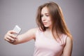 Closeup portrait of young cheerful readhead woman makes selfie on smartphone