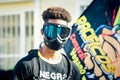 Closeup portrait of young dominican man in black mask against colorful flag