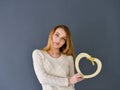 Closeup portrait of young female holding heart shape isolated on gray background Royalty Free Stock Photo