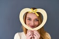 Closeup portrait of young female holding heart shape isolated on gray background Royalty Free Stock Photo