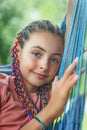 Closeup portrait of young girl with colorful braids in her hair