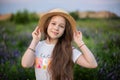 Closeup portrait of young girl with long hair and straw hat relaxing on blooming lupine field. Childhood. Copy space. Beautiful ha Royalty Free Stock Photo