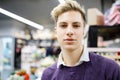 Closeup portrait of young handsome guy in store. The guy poses in front of the camera