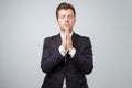 Closeup portrait of young handsome male in suit, in meditation pose, relaxing, in zen, isolated on white background Royalty Free Stock Photo