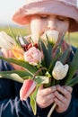Closeup portrait of a young happy preteen girl holding a bunch of tulips and smelling the flowers Royalty Free Stock Photo