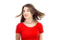 Closeup portrait of a young happy smiling girl in red t-shirt, wind blows her hair against white background Royalty Free Stock Photo