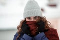 Closeup portrait of a young happy woman enjoying winter wearing scarf and knitted hat Royalty Free Stock Photo