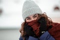 Closeup portrait of a young happy woman enjoying winter wearing scarf and knitted hat Royalty Free Stock Photo