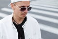 Closeup portrait of a young hipster man in a fashionable white jacket in a black t-shirt in a stylish baseball cap Royalty Free Stock Photo