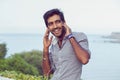 Closeup portrait Young Indian Asian Male College Student Indian teenage boy listening to music audio books studying on his phone Royalty Free Stock Photo