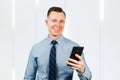Closeup portrait of young man businessman dressed in blue shirt and tie, talking on the mobile phone Royalty Free Stock Photo