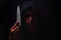 Closeup portrait of a young man in a hoodie, holding a knife in Royalty Free Stock Photo