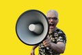 Closeup portrait of a young man screaming into a megaphone Royalty Free Stock Photo