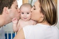 Closeup portrait of young parents kissing beautiful newborn son Royalty Free Stock Photo