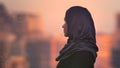 Closeup portrait of young pretty female in hijab looking forward with urban setting and shining buildings on the Royalty Free Stock Photo