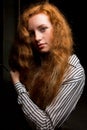 Closeup portrait of young red haired model with long lush hair.