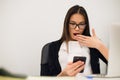 Closeup portrait young, shocked business woman, looking at cell phone seeing bad text message, email, isolated indoors Royalty Free Stock Photo