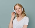 Closeup portrait of young woman closed eyes listening music via headphones on color neutral gray tone Royalty Free Stock Photo