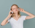 Closeup portrait of young woman closed eyes listening music via headphones on color neutral gray tone Royalty Free Stock Photo